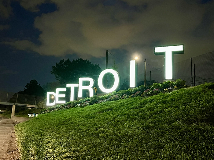 Cover image for 'The New Detroit Sign on I-94: Everything You Want to Know'. Image is of the Detroit sign off highway I-94 at night.
