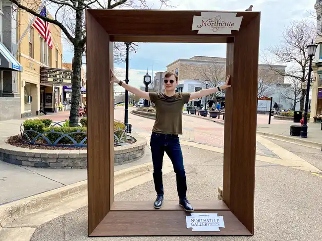 A giant open picture frame in downtown Northville from The Northville Gallery for visitors to step in for a photo opportunity.